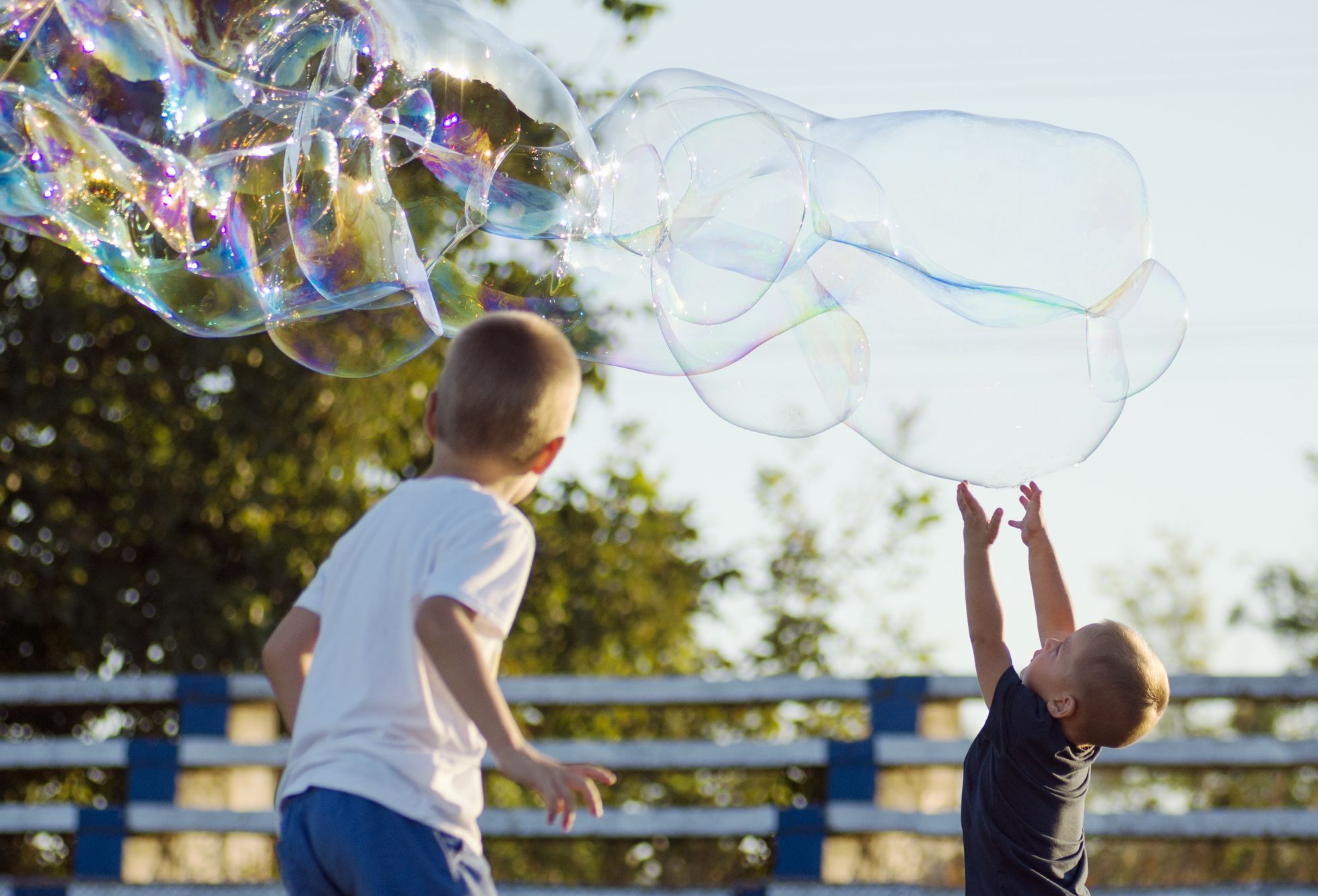 A boy making a giant soap bubble.