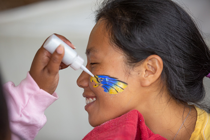 A young woman gets an eagle painted on her face