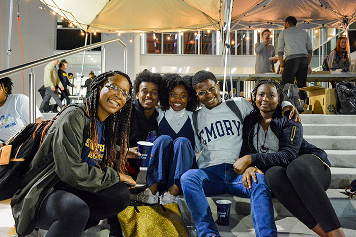 Five students sit on the steps outside of the Emory Student Center